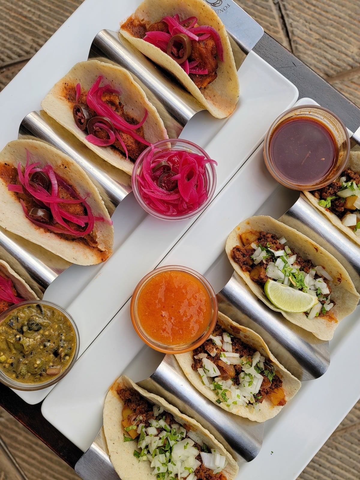 A spread of tacos with salsas at Fonda's Taqueria